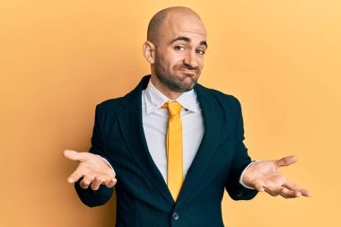 Genç İspanyol takım elbiseli, kravatlı, aptal ve elleri havada, kafası karışmış bir adam. şüphe kavramı. 