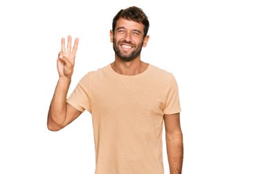 Yakışıklı, sakallı, sıradan tişörtlü, üç numaralı parmaklarıyla gösteriş yapan, kendinden emin ve mutlu bir genç.. 