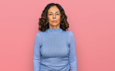 Yüzünde ciddi bir ifade olan günlük kıyafetler giyen orta yaşlı İspanyol bir kadın. Basit ve doğal bir şekilde kameraya bakıyorsun.. 