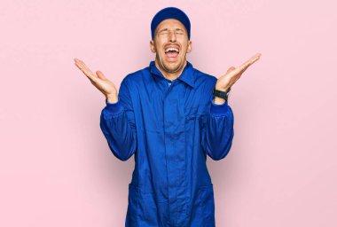 Kel ve sakallı bir adam, inşaatçı tulumu giymiş, çılgın ve başarının kutlamasını yapıyor. Kolları havada, gözleri kapalı, heyecanla bağırıyor. Kazanan konsept 