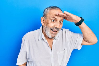 Sakallı, sıradan, beyaz tişörtlü, çok mutlu ve tebessüm eden yakışıklı bir adam. arama kavramı. 