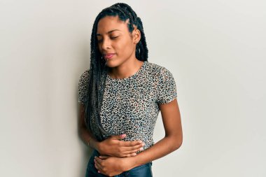 Afro-Amerikalı kadın, hazımsızlık, acı veren hastalıklar yüzünden elleri karnında günlük kıyafetler giyiyor. Ağrı kavramı. 