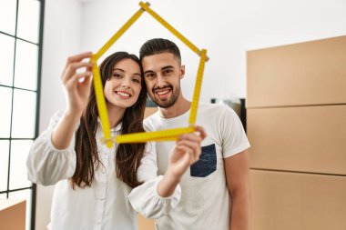 Genç İspanyol çift gülümsüyor mutlu ev projeleri yeni evinde tutuluyor.