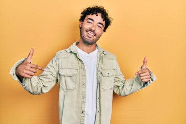 Günlük kıyafetler giyen, kendine güveni olan, kendini gururlu ve mutlu gösteren genç İspanyol bir adam.. 