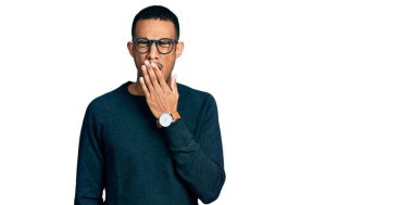 Gündelik kıyafetler ve gözlük takan genç Afro-Amerikan adam ağzıyla ağzını kapatmaktan sıkıldı. Huzursuz ve uykulu.. 