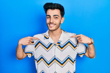 Günlük kıyafetler giyen, kendine güveni olan, kendini gururlu ve mutlu gösteren genç İspanyol bir adam.. 