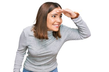 Balıkçı yaka kazak giyen genç ve güzel bir kadın çok mutlu ve tebessüm ediyor. arama kavramı. 