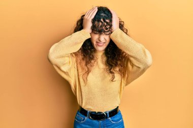 Genç İspanyol kız gündelik kıyafetler giyiyor. Baş ağrısı çekiyor. Acı ve migren yüzünden çaresiz ve stresli. Eller başının üstünde.. 