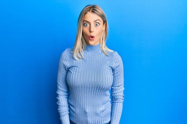 Güzel sarışın kadın gündelik kıyafetler giyiyor. Şaşırmış ve korkmuş bir ifade, korku ve heyecanlı bir yüz ifadesi var.. 