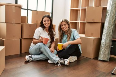 Genç çift mutlu bir şekilde gülümsüyor. Yeni evinde bir fincan kahve içiyor..