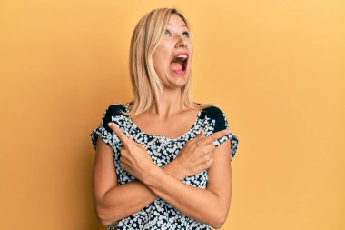 Orta yaşlı, beyaz bir kadın farklı yönleri işaret ediyor kızgın ve kızgın çığlıklar atıyor öfkeyle bağırıyor, öfkeyle yukarı bakıyor.. 