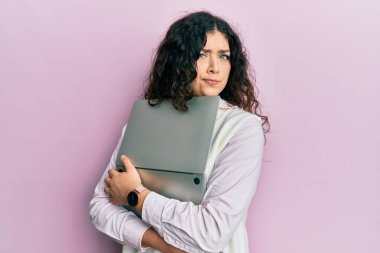 Genç esmer, kıvırcık saçlı, dizüstü bilgisayarına sarılan, kuşkucu ve gergin bir kadın. Sorunları yüzünden surat asıyor. negatif kişi. 