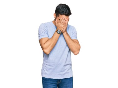 Ağlarken suratını ellerle kapatan, günlük kıyafetler giyen genç İspanyol. depresyon kavramı. 