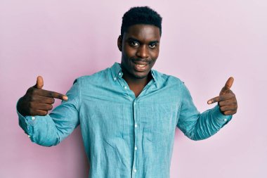 Yakışıklı, sıradan kıyafetler giyen, kendine güvenen, yüzünde gülümseme olan, kendini gururlu ve mutlu gösteren siyahi bir adam.. 