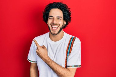 Yakışıklı ispanyol adam parmaklarını kenarı işaret ederek gülüyor ve kahkahalarla gülüyor çünkü komik çılgın bir şaka.. 