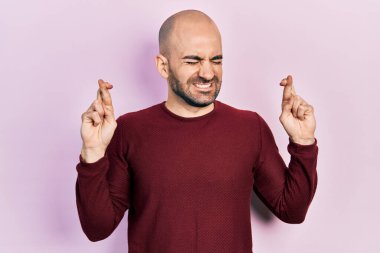 Sıradan kıyafetler giyen genç kel adam umut ve gözlerin kapalı gülümseyerek el sallıyor. Şans ve batıl inançlar. 