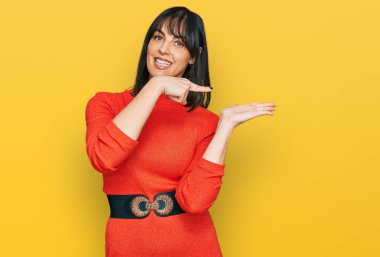 Gündelik kıyafetler giyen genç İspanyol kadın kameraya hayret ediyor ve gülümsüyor.. 