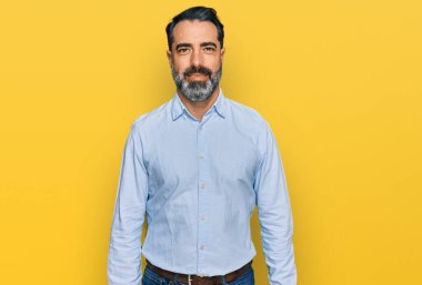 Sakallı, iş gömleği giyen mutlu ve havalı bir gülümsemesi olan orta yaşlı bir adam. şanslı kişi. 