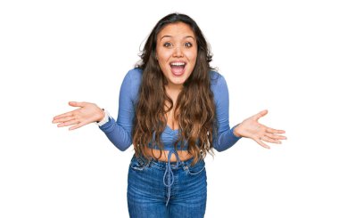 Genç İspanyol kız gündelik giysiler giyip çılgınlığı kutluyor ve başarıya hayret ediyor kolları açık ve gözleri açık heyecanla haykırıyor. Kazanan konsept 