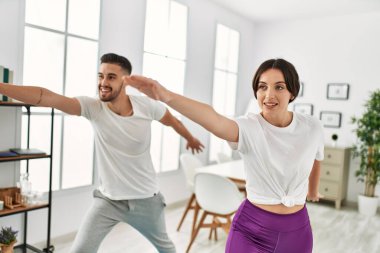 Genç İspanyol çift evde yoga yapıyor.