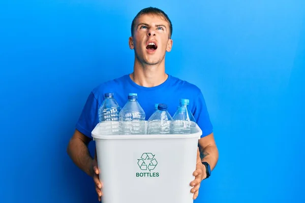 Jovem Caucasiano Segurando Lixo Reciclável Com Garrafas Plástico Irritado Louco — Fotografia de Stock