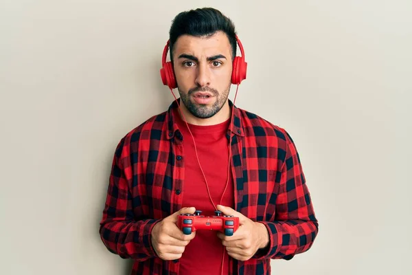 Mladý Hispánec Hraje Videohry Drží Ovladač Šoku Tvář Vypadá Skeptický — Stock fotografie