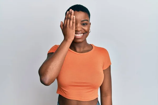 Молодая Африканская Американка Обычной Оранжевой Футболке Закрывающей Один Глаз Рукой — стоковое фото