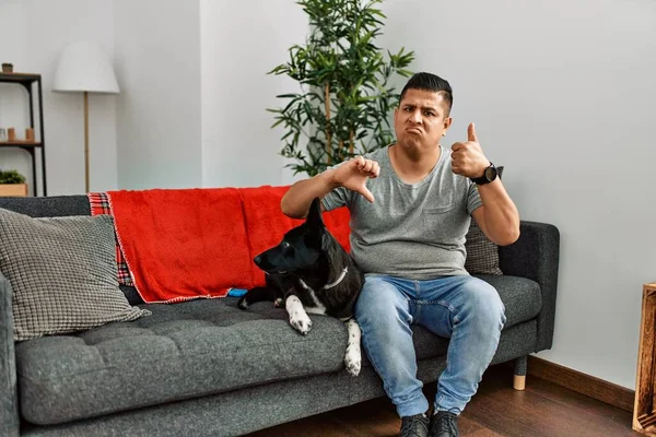Jovem Latino Cão Sentado Sofá Casa Fazendo Polegares Para Cima — Fotografia de Stock
