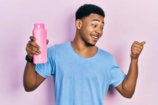 Jonge Afro Amerikaanse Man Met Shampoo Fles Wijzen Duim Naar — Stockfoto