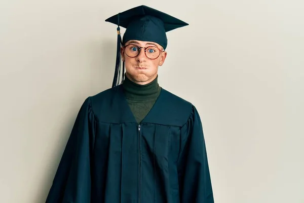 Young Caucasian Man Wearing Graduation Cap Ceremony Robe Puffing Cheeks — Stock Photo, Image