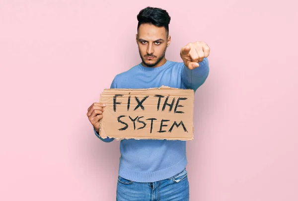 Młody Arabski Mężczyzna Trzyma Naprawić System Baner Karton Wskazując Palcem — Zdjęcie stockowe