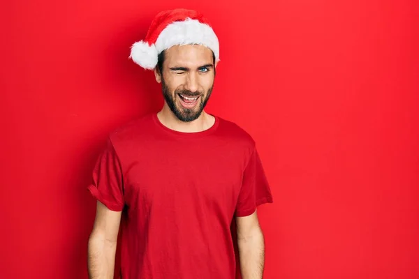 Νεαρός Ισπανός Άνδρας Χριστουγεννιάτικο Καπέλο Κλείνει Μάτι Κοιτάζοντας Την Κάμερα — Φωτογραφία Αρχείου