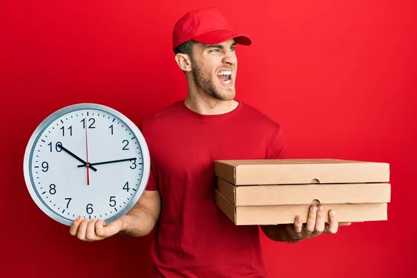 Joven Hombre Caucásico Sosteniendo Paquete Entrega Reloj Enojado Loco Gritando —  Fotos de Stock