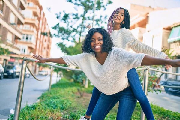 美しいですアフリカ系アメリカ人の母親与え娘Piggyback乗り物とともにオープン腕でザ公園 — ストック写真