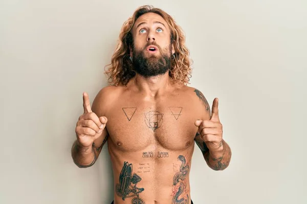 Jóképű Szakállas Hosszú Hajú Férfi Félmeztelen Tetovált Csodálkozó Meglepett Ujjal — Stock Fotó