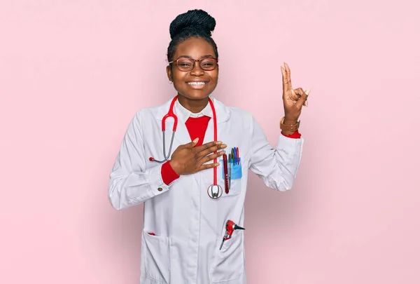 Young african american woman wearing doctor uniform and stethoscope smiling swearing with hand on chest and fingers up, making a loyalty promise oath