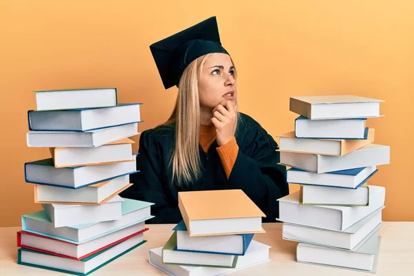 Mujer Joven Caucásica Vestida Con Bata Ceremonia Graduación Sentada Mesa — Foto de Stock