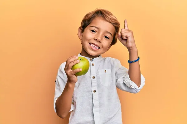 Adorable Latin Kid Holding Green Apple Smiling Idea Question Pointing — Stock Photo, Image