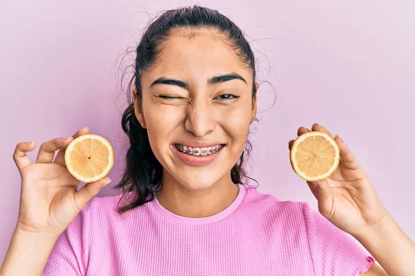 Латиноамериканка Подросток Зубными Скобками Держа Лимон Подмигивая Смотрит Камеру Сексуальным — стоковое фото