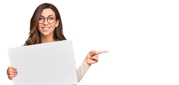 Young Brunette Woman Holding Blank Empty Banner Smiling Happy Pointing — Stock Photo, Image