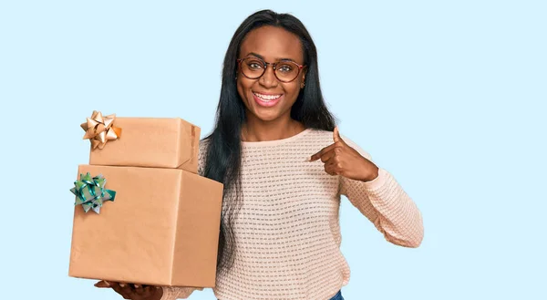 Young Black Woman Holding Gifts Pointing Finger One Self Smiling — Stock Photo, Image
