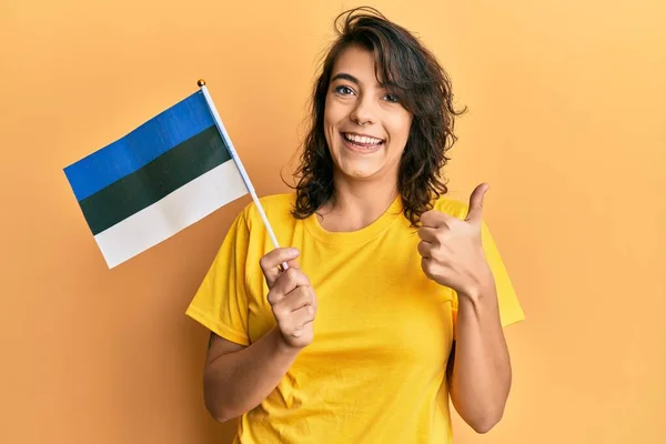 Young Hispanic Woman Holding Estonia Flag Smiling Happy Positive Thumb — Stock Photo, Image