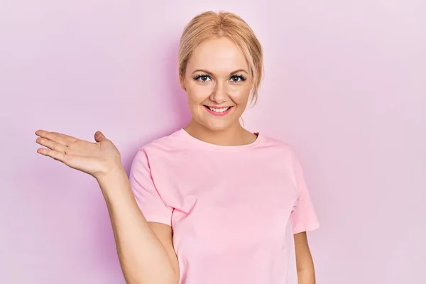 Młoda Blondynka Ubrana Luźny Różowy Shirt Uśmiechnięta Radosna Prezentacja Wskazująca — Zdjęcie stockowe