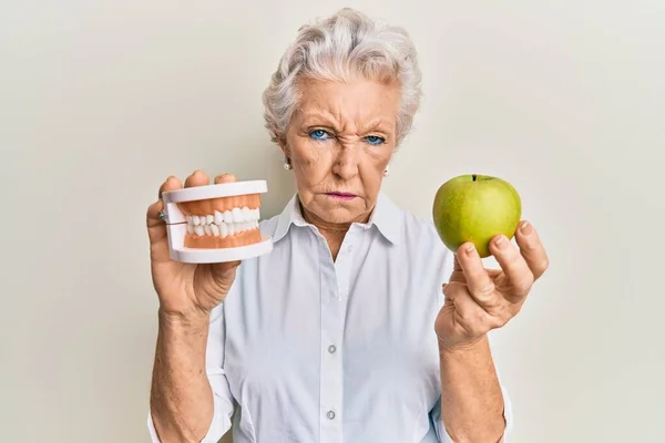 Senior Mulher Cabelos Grisalhos Segurando Maçã Verde Dentes Dentadura Cético — Fotografia de Stock