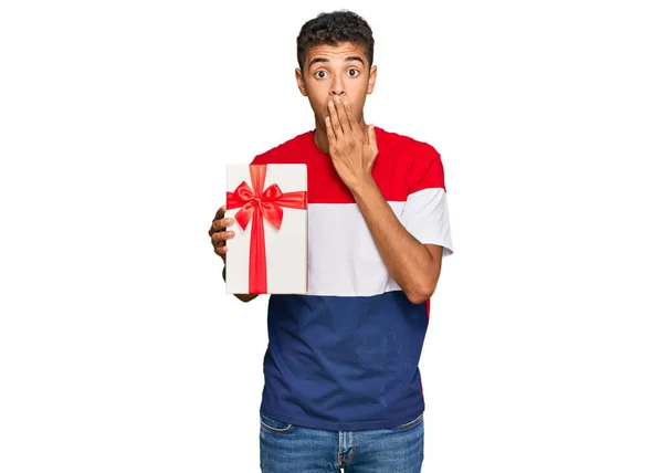 Young Handsome African American Man Holding Gift Covering Mouth Hand — Stock Photo, Image