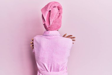 Kadın elbisesi giyen genç adam duş havlusu giyerek ve bornozunu giyerek mutlu ve pozitif bir şekilde sarılarak makyaj yapıyor. Sevgi ve özgüven. 