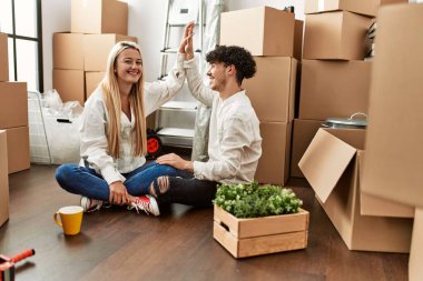 Genç ve güzel bir çift gülümsüyor. Mutlu bir kutlama yapıyorlar. Yeni evlerinde eller havada..