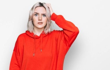 Gündelik kıyafetler giyen genç sarışın kız kafaları karıştırıyor ve soru soruyor. Şüpheyle kararsız, kafa kafaya düşünerek. Düşünceli kavram. 