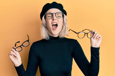 Yüzüne cam parçaları takan genç sarışın kız kızgın ve kızgın bağırıyor sinirlenmiş ve öfkeli, öfkeyle bağırıyor.. 