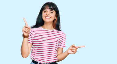 Gündelik kıyafetler giyen, kendine güvenen, parmaklarını farklı yönlere çeviren genç İspanyol kız. reklam için kopyalama alanı 